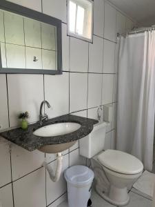 a bathroom with a sink and a toilet at Pousada Amora Caraiva in Caraíva