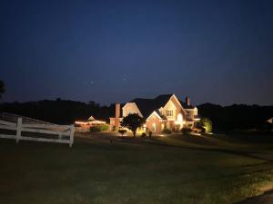 a house with lights on in a yard at night at The Retreat at Davis Mill in Germantown