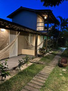 uma casa com uma rede na frente em Pousada Amora Caraiva em Caraíva