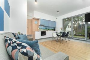 a living room with a couch and a table with chairs at Apartament Niebieski c4 in Pobierowo