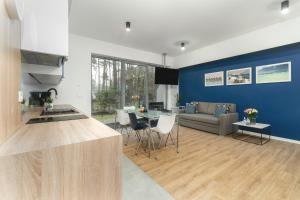 a kitchen and living room with a couch and a table at Apartament Niebieski c4 in Pobierowo