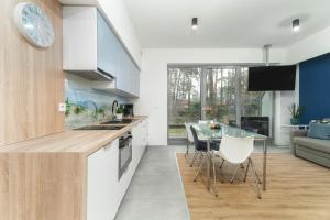 a kitchen and living room with a table and chairs at Apartament Niebieski c4 in Pobierowo +28 photos