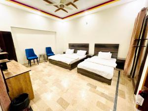 卡拉奇的住宿－Airport Hotel Bed & Rest，一间卧室配有两张床和两张蓝色椅子