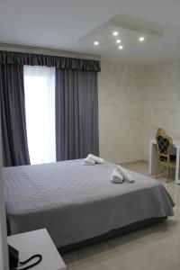 1 dormitorio con 1 cama con 2 toallas en Hotel Presidente, en Porto Cesareo