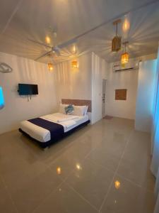 a bedroom with a bed in a room with lights at Saima Lodge in Himandhoo 