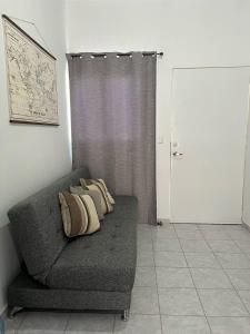 een bank met drie kussens in een kamer bij Cozy Home in San Miguel