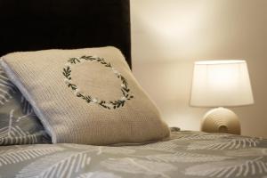 un cuscino sopra un letto con lampada di Cute Duplex Apartment in Leeds a Kirkstall