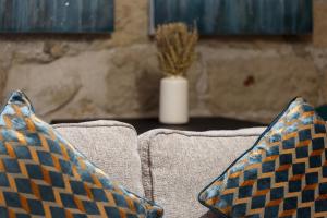 two pillows sitting on top of a couch with a plant at Cute Duplex Apartment in Leeds in Kirkstall