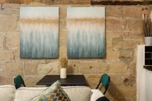 a brick wall with three paintings on it at Cute Duplex Apartment in Leeds in Kirkstall