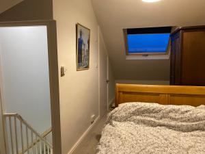 een slaapkamer met een bed en een klein raam bij Castle View in Windsor