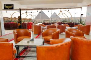 un restaurante con sillas, mesas y pirámides en Comfort Inn Giza, en El Cairo
