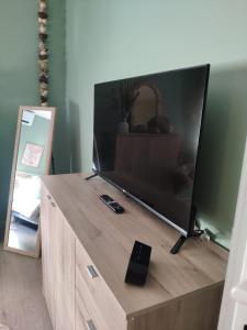 a large flat screen tv sitting on top of a wooden entertainment center at LE MANHATTAN Authentique maison climatisée 78 m2 in Brasles