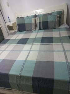 a bed with a blue and green plaid blanket at Azure Urban Resort Staycation By Owner Only in Manila