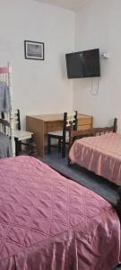 ロサリオ・デ・ラ・フロンテラにあるDpto gonzaloのベッド2台、薄型テレビが備わる客室です。