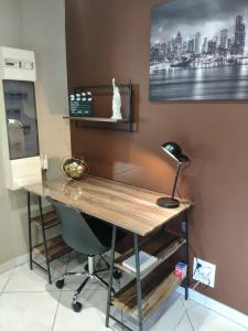 escritorio con silla y lámpara en la pared en LE MANHATTAN Authentique maison climatisée 78 m2, en Brasles