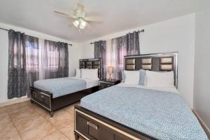a bedroom with two beds and a ceiling fan at Luxurious 5 bedrooms Jacuzzipool in Miramar