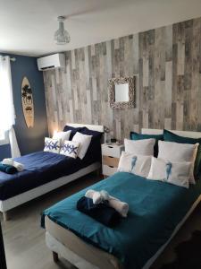 2 camas en un dormitorio con azul y blanco en LE MANHATTAN Authentique maison climatisée 78 m2, en Brasles