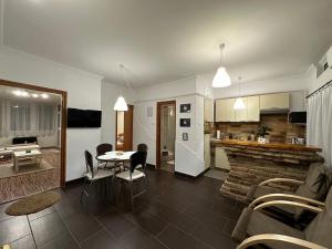 a kitchen and a living room with a table and chairs at Central Apartman Makó in Makó