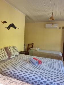 a bedroom with two beds and two birds on the wall at Chalés Rio Bonito in Imbassai