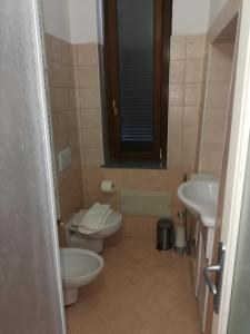 a bathroom with a toilet and a sink at Iori's House in Mergozzo