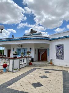 Biały dom z niebieskim dachem w obiekcie Slama w mieście Nabul