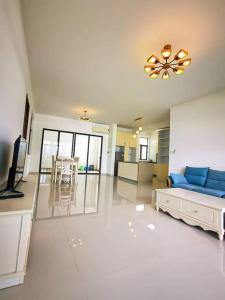 ein Wohnzimmer mit einem blauen Sofa und einem Tisch in der Unterkunft ForestCity Cerulean Bay 4 Room Near Duty Free Shop in Kampong Tanjong Kupang