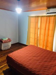 a bedroom with a bed with a red comforter and a window at Joly in Wanda