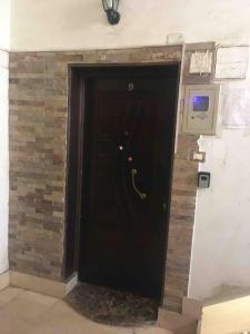 a black door in a room with a brick wall at Super Cozy Apt 7 min to CAI in Cairo