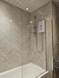 prysznic ze szklaną kabiną prysznicową z prysznicem w obiekcie The Crannog on Loch Tay w mieście Morenish
