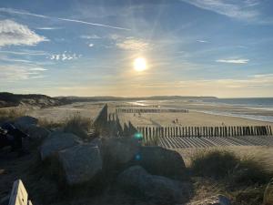 ein Strand mit einem Zaun und Menschen am Strand in der Unterkunft Duplex à Wissant 115m2-terrasse- vrai weekend jusque 16h le dimanche in Wissant