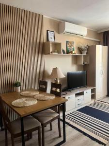 a dining room table with chairs and a television at Paradise dreams Velingrad in Velingrad