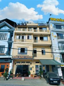 a tan building with a sign on it at Minh Hưng Hostel in Sa Pa