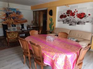 ein Esszimmer mit einem Tisch und einem Sofa in der Unterkunft villa ROSE GARDEN in Craponne-sur-Arzon