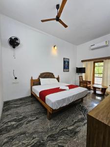 a bedroom with a large bed and a fan at Lake facing Villa-Water sport activities-Niva Waterways in Vaikom