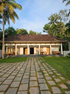 a building with a palm tree in front of it at Lake facing Villa-Water sport activities-Niva Waterways in Vaikom