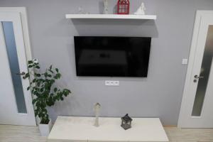 un soggiorno con TV su una parete bianca di Moderný priestranný apartmán a Rimavská Sobota