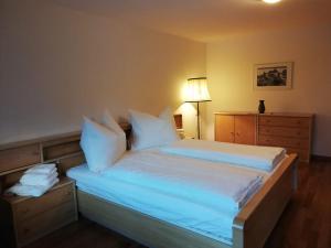 a bedroom with a large bed with white sheets and pillows at Alpenwohnungen Ruprecht Montafon in Schruns