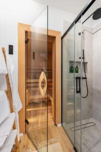 um chuveiro de vidro num quarto com piso de madeira em SZUMI ROSA 
