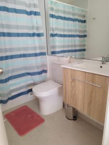 a bathroom with a toilet and a sink and a shower at Departamento Frente al Mar in Coquimbo