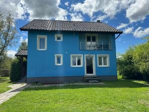 a blue house with a green yard at Villa Plavi Lav Potok in Potok