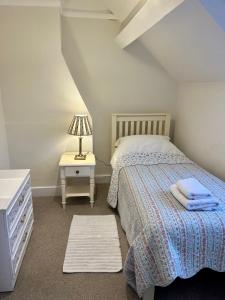 a bedroom with a bed and a table with a lamp at The Cottage in Abergavenny