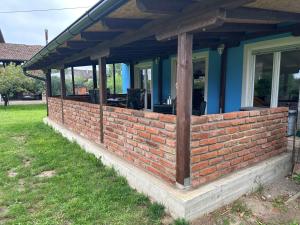 un muro di mattoni che mantiene una casa di Villa Plavi Lav Potok a Potok