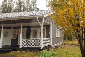 una piccola casa grigia con una veranda bianca di Villa Vanamo ad Äkäslompolo