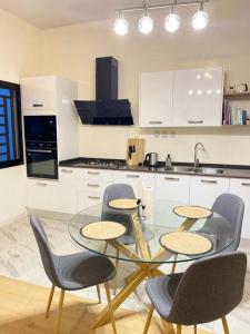 a kitchen with a glass table and four chairs at Villa Mamath 