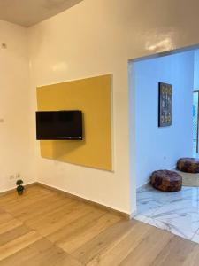 sala de estar con TV en la pared en Villa Mamath 
