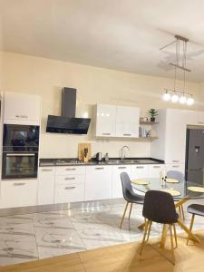a kitchen with white cabinets and a table and chairs at Villa Mamath 