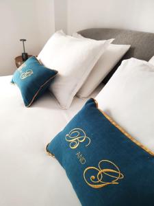 a bed with white pillows and a blue towel on it at B and G San Babila luxury in the heart of Milano - Design district in Milan