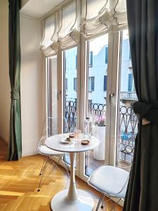 a white table and chairs in a room with a window at B and G San Babila luxury in the heart of Milano - Design district in Milan