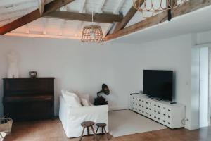ein Wohnzimmer mit einem weißen Sofa und einem TV in der Unterkunft Rincón de ensueño en Uribe Kosta 