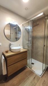 a bathroom with a sink and a shower with a mirror at O pisiño de Vista Alegre in Vilagarcia de Arousa